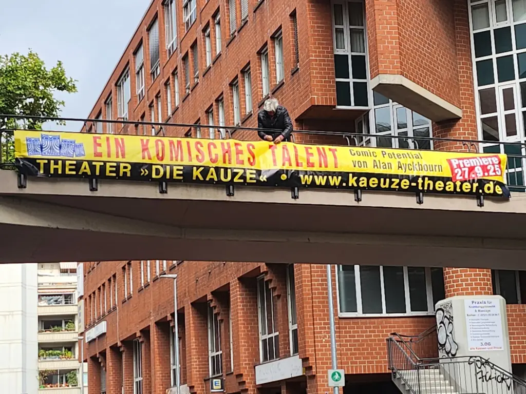 Ein bedrucktes Spannband wird an einer Brücke befestigt.
