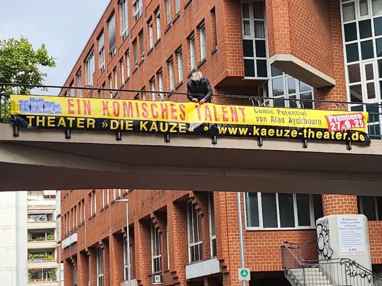 Ein bedrucktes Spannband wird an einer Brücke befestigt.