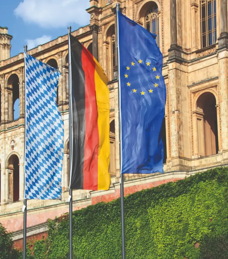 Drei Fahnenmasten ohne Auslegerfunktion mit gehissten Länderflaggen vor dem Bayerischen Landtag