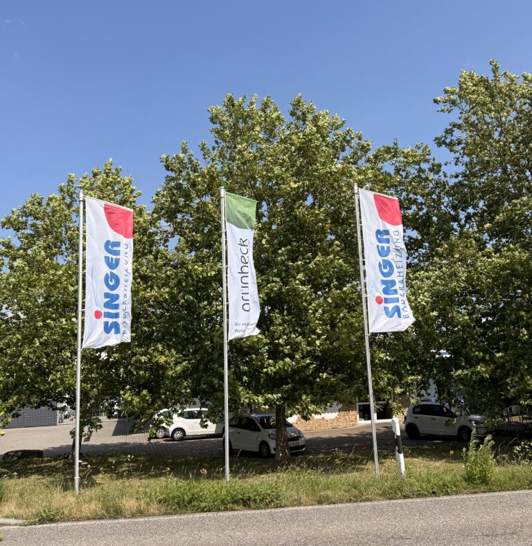 Outdoor Werbefahne mit Auslegerkonfektion mit Kundenlogo bedruckt wehen vor Bäumen