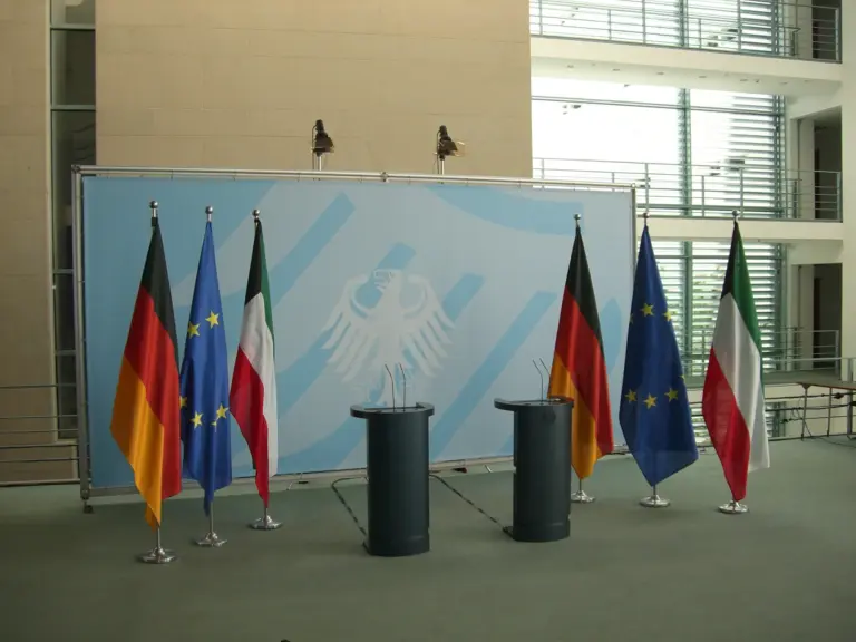 Sechs Einzelraumständer mit Fahnen bei einer Pressekonferenz