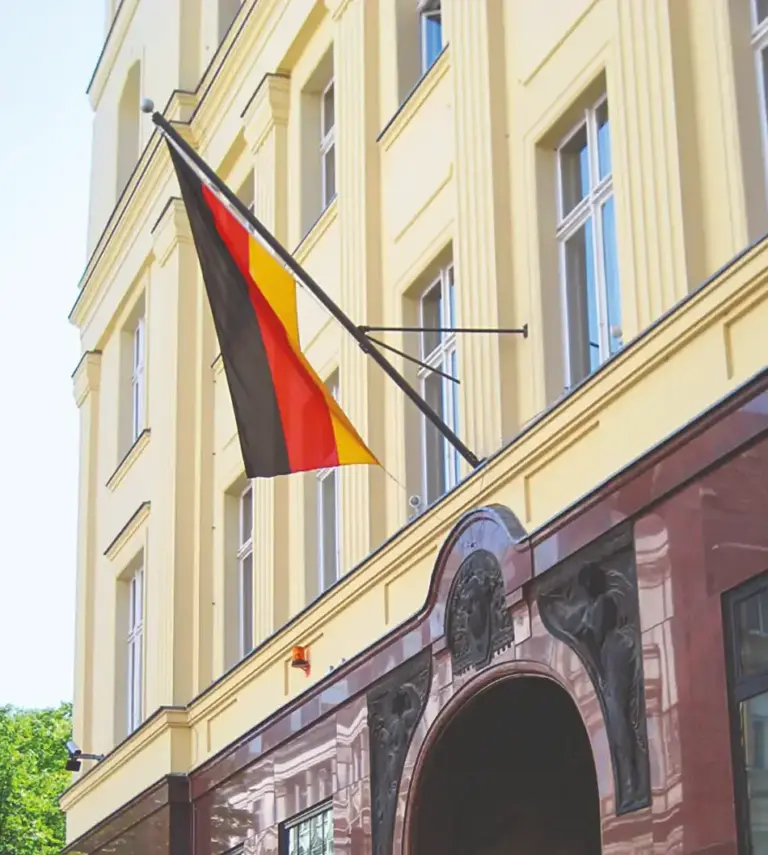 Deutschlandfahne schräg hängend an einem Fassadenmast