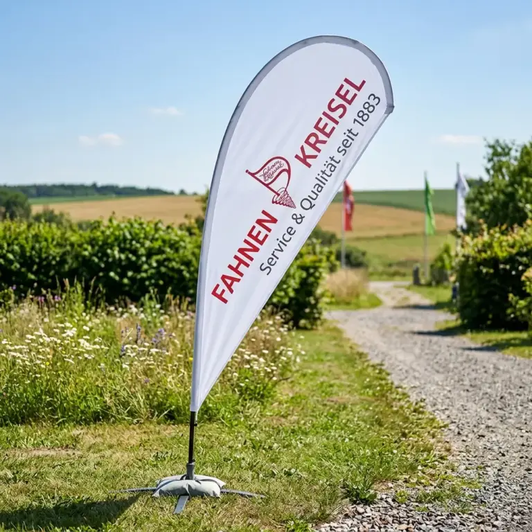 Ein bedrucktes Beachflag stehend auf Gras