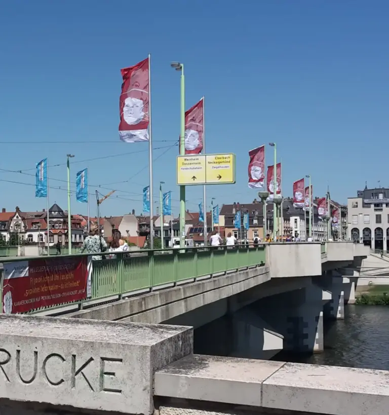 Mehrere individuell bedruckte Werbefahnen wehen an einer Brücke