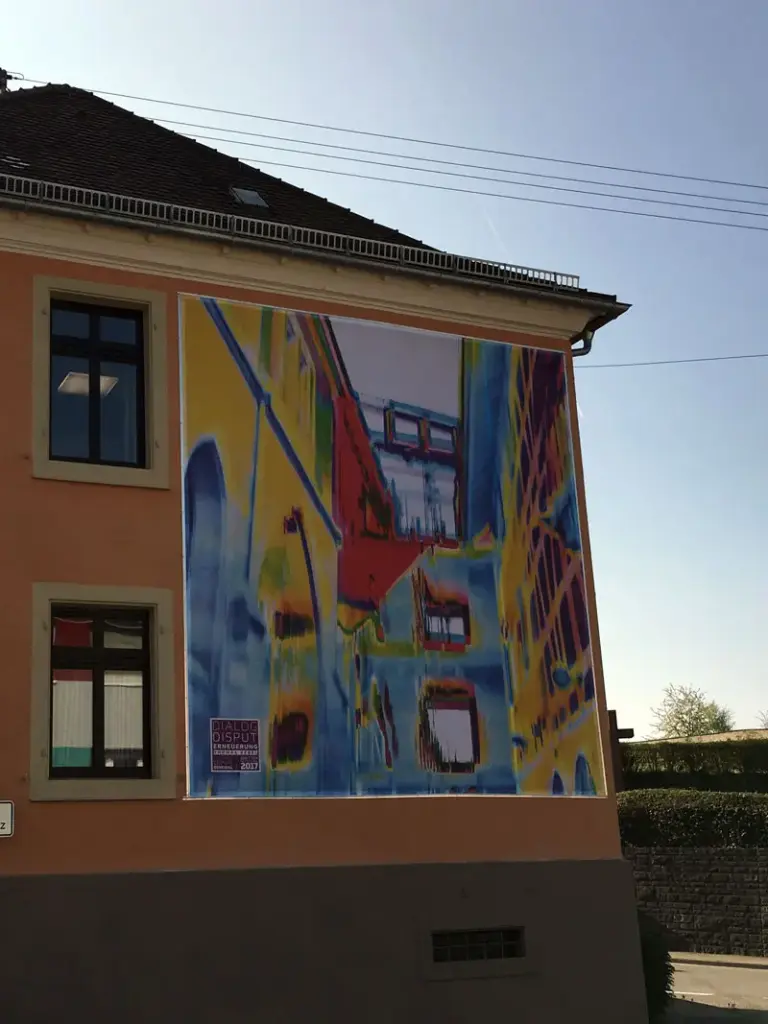 Eine bedruckte XXL-Fassadenwerbung an einer Hauswand.