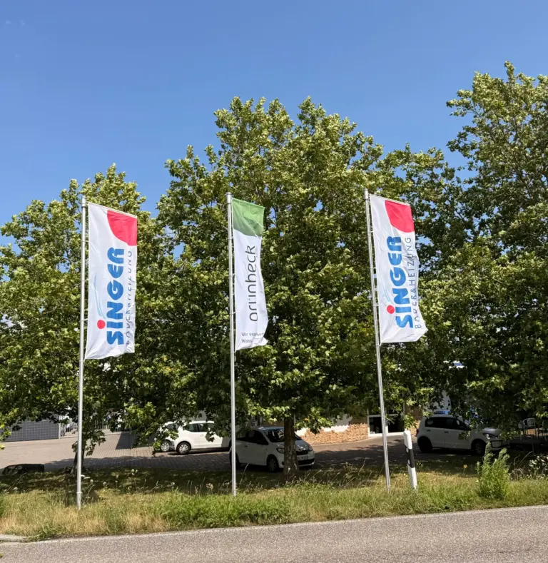 Outdoor Werbefahne mit Auslegerkonfektion mit Kundenlogo bedruckt wehen vor Bäumen